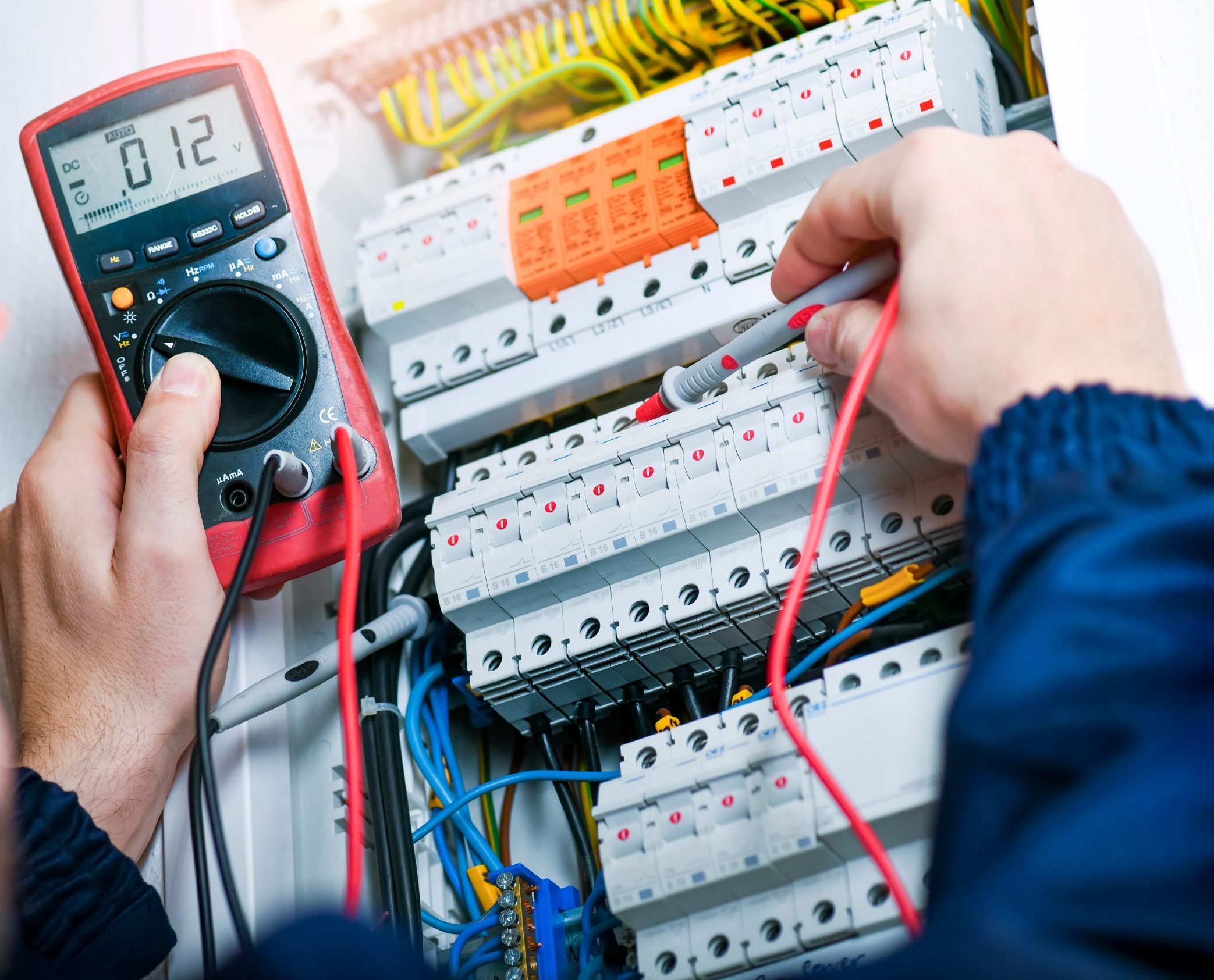 lectrician installing electric cable wires and fuse switch box.