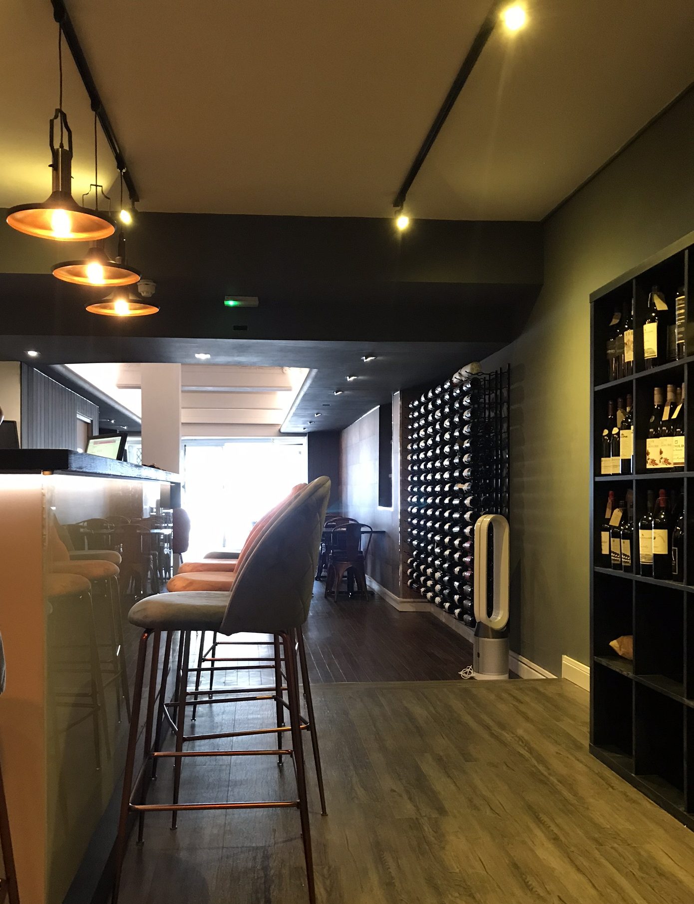 Modern lighting fixtures illuminating the interior of a high-end wine bar