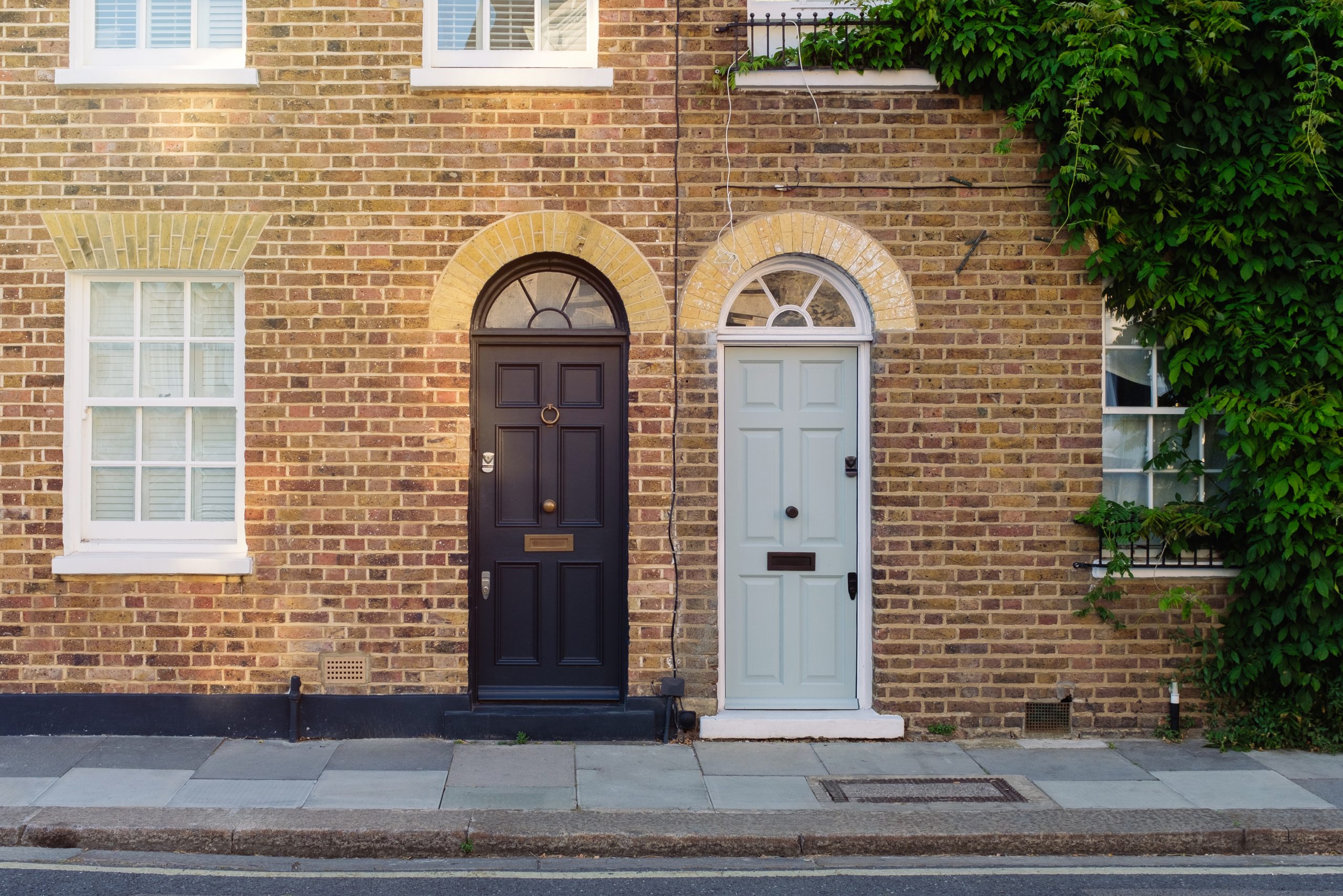 Front doors of two old neighbouring town houses on a street in an English city